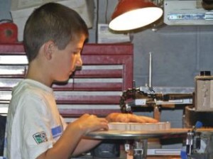 Isaiah cuts a project on the Hawk G4 scroll saw he bought with his own money.